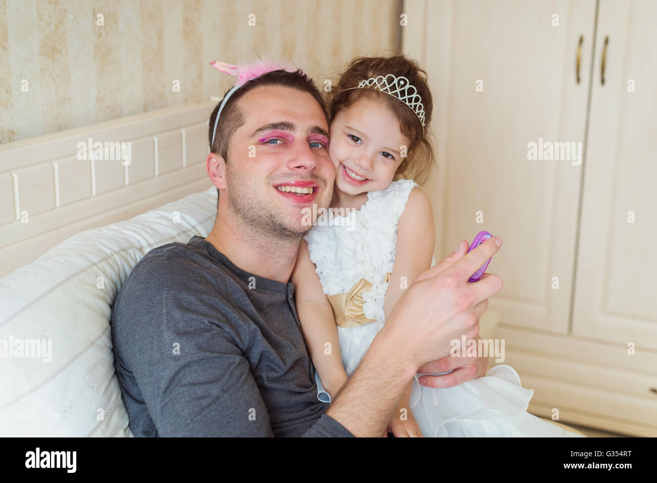 Süße Mädchen, das auf Make-up auf ihr Vater Stockfoto