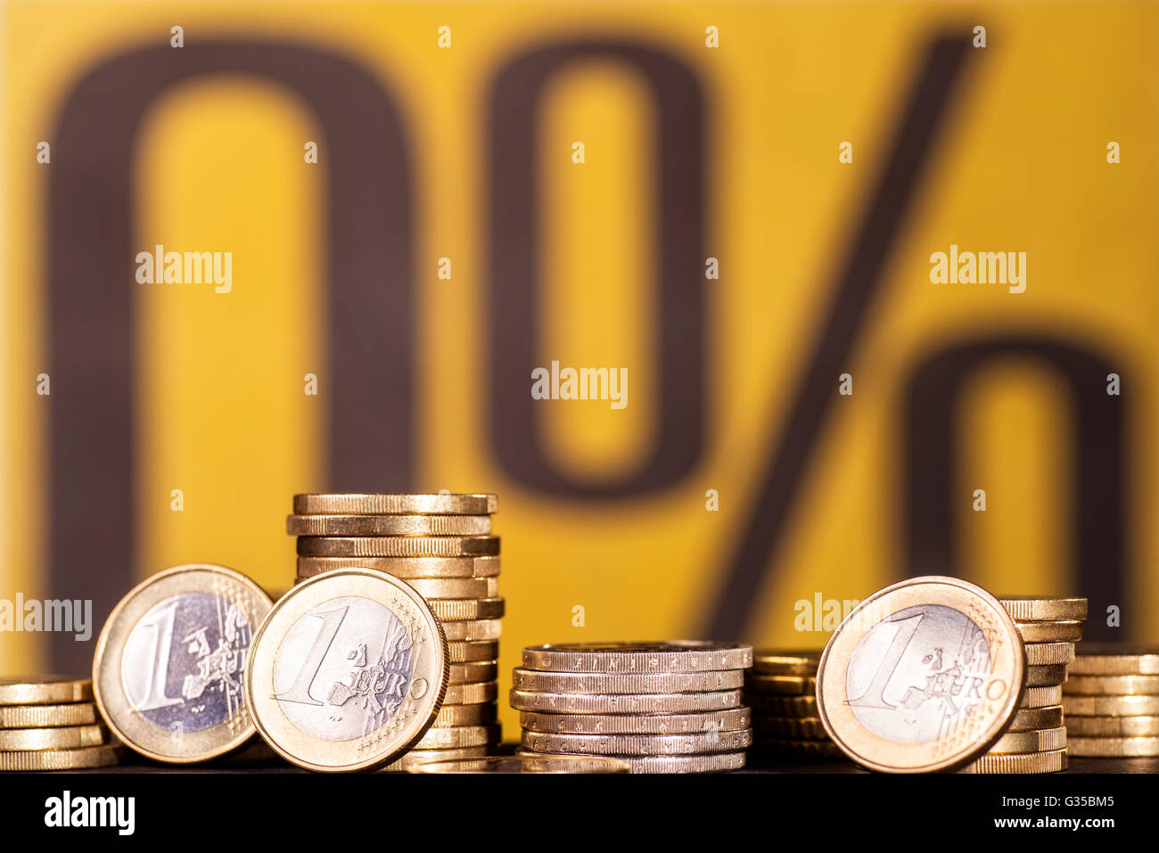 Münzen mit dem Symbol für 0% Zinsen im Hintergrund Stockfoto