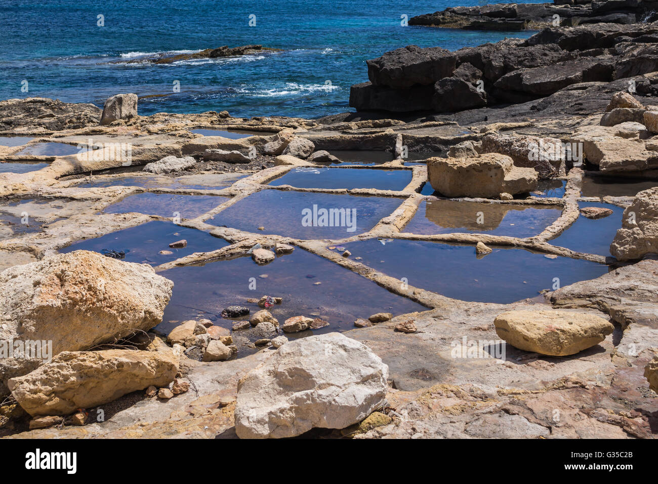 Löcher in Felsen an der Küste des Mittelmeers, zur Verdunstung des Wassers und Meersalz. Stadt Marsaskala, Insel Stockfoto