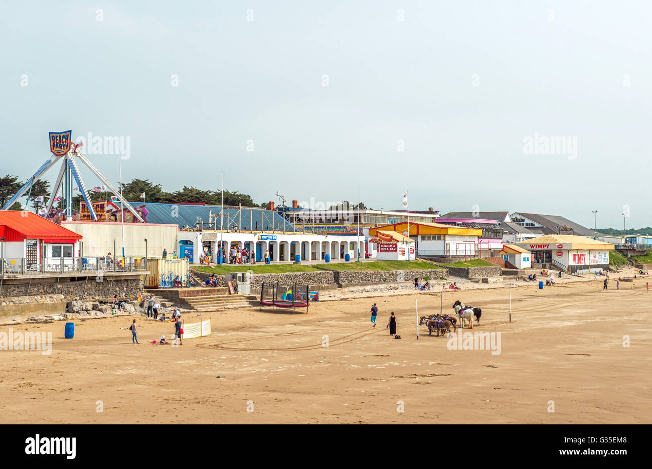 Coney Strand Porthcawl an der Südküste von Wales zeigt die Kirmes, mit Leuten zu spielen und ein Spaziergang an einem sonnigen Junitag Stockfoto