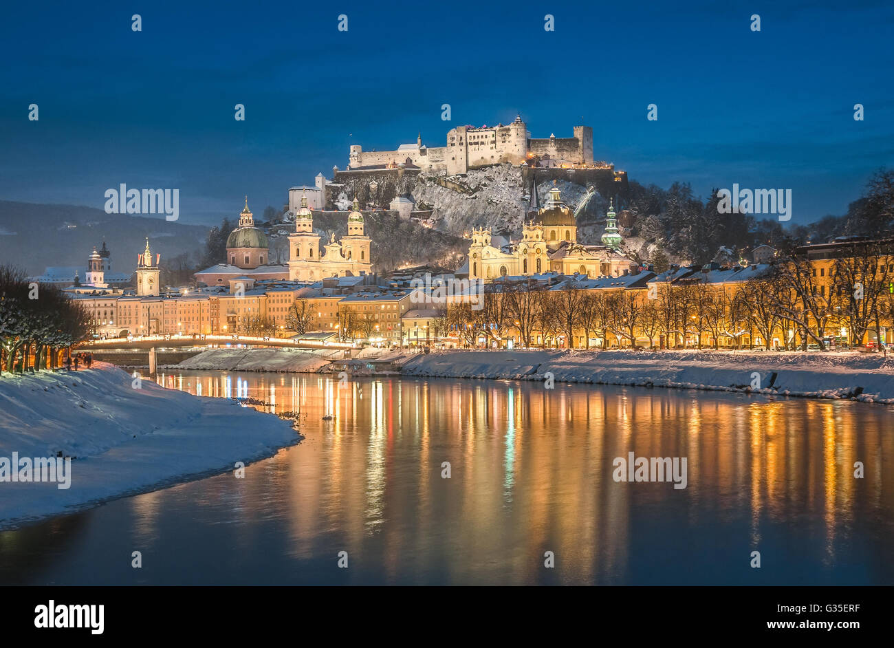 Schöne Aussicht auf die Altstadt von Salzburg mit Salzach Fluss im Winter während der blauen Stunde, Salzburger Land, Österreich Stockfoto