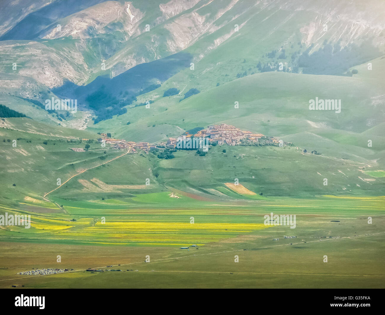 Schönen Sommerlandschaft am Piano Grande mit Dorf Castelluccio di Norcia und Berg-Plateau in den Apenninen Stockfoto