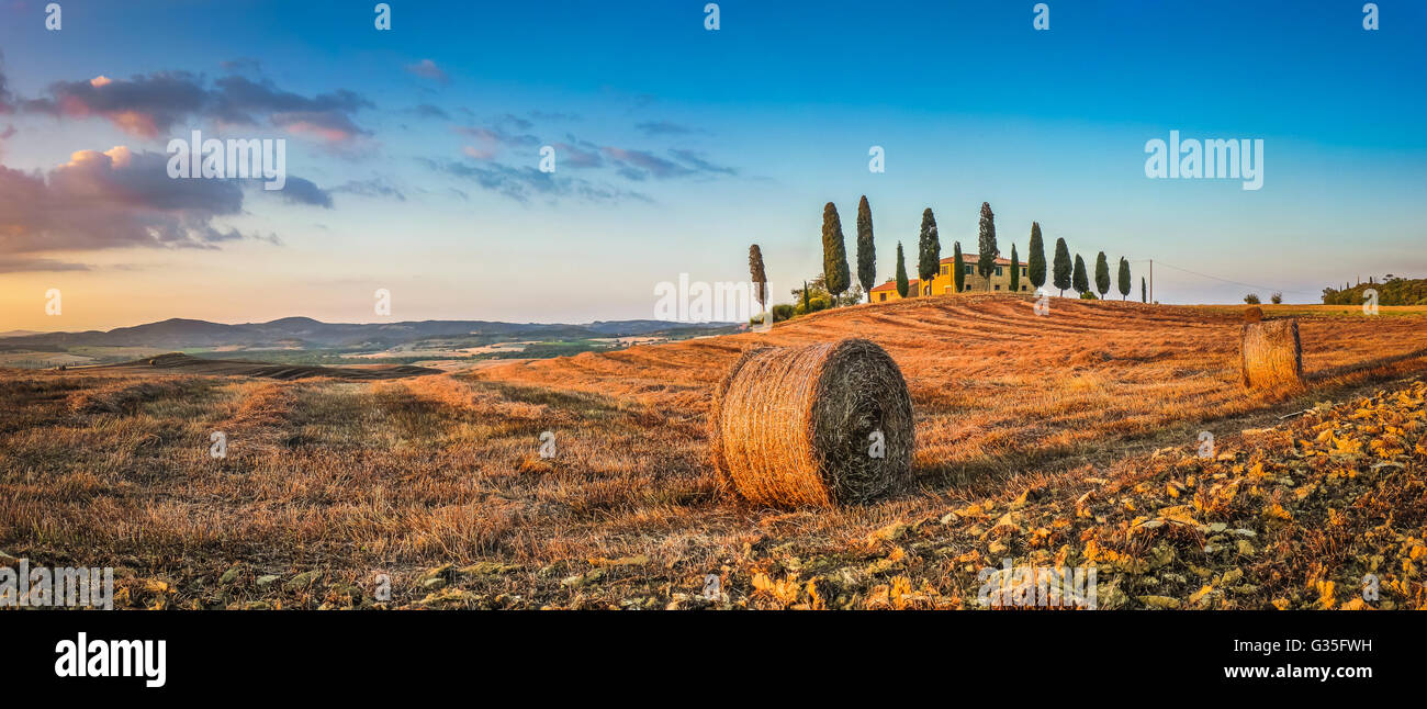 Panorama des toskanischen Landschaft mit traditionellen Bauernhof Haus und Heuballen im goldenen Abendlicht, Val d ' Orcia, Italien Stockfoto