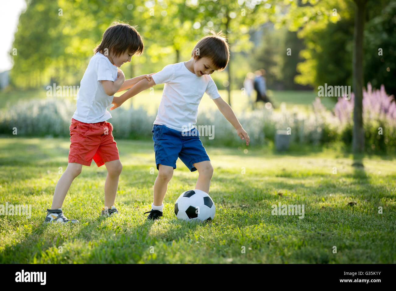 Zwei süße kleine Kinder, gemeinsam Fußball zu spielen, im Sommer. Kinder  spielen Fußball im freien Stockfotografie - Alamy