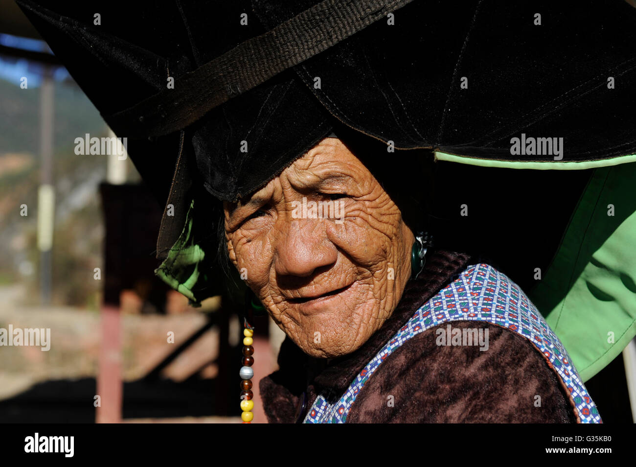 CHINA Yunnan, ethnische Minderheiten, Yi-Frau mit einem traditionellen verzierten schwarzen Hut / CHINA Provinz Yunnan, Ethnische antidiskriminatorische, Yi Frau Mit Schwarzem Hut Stockfoto