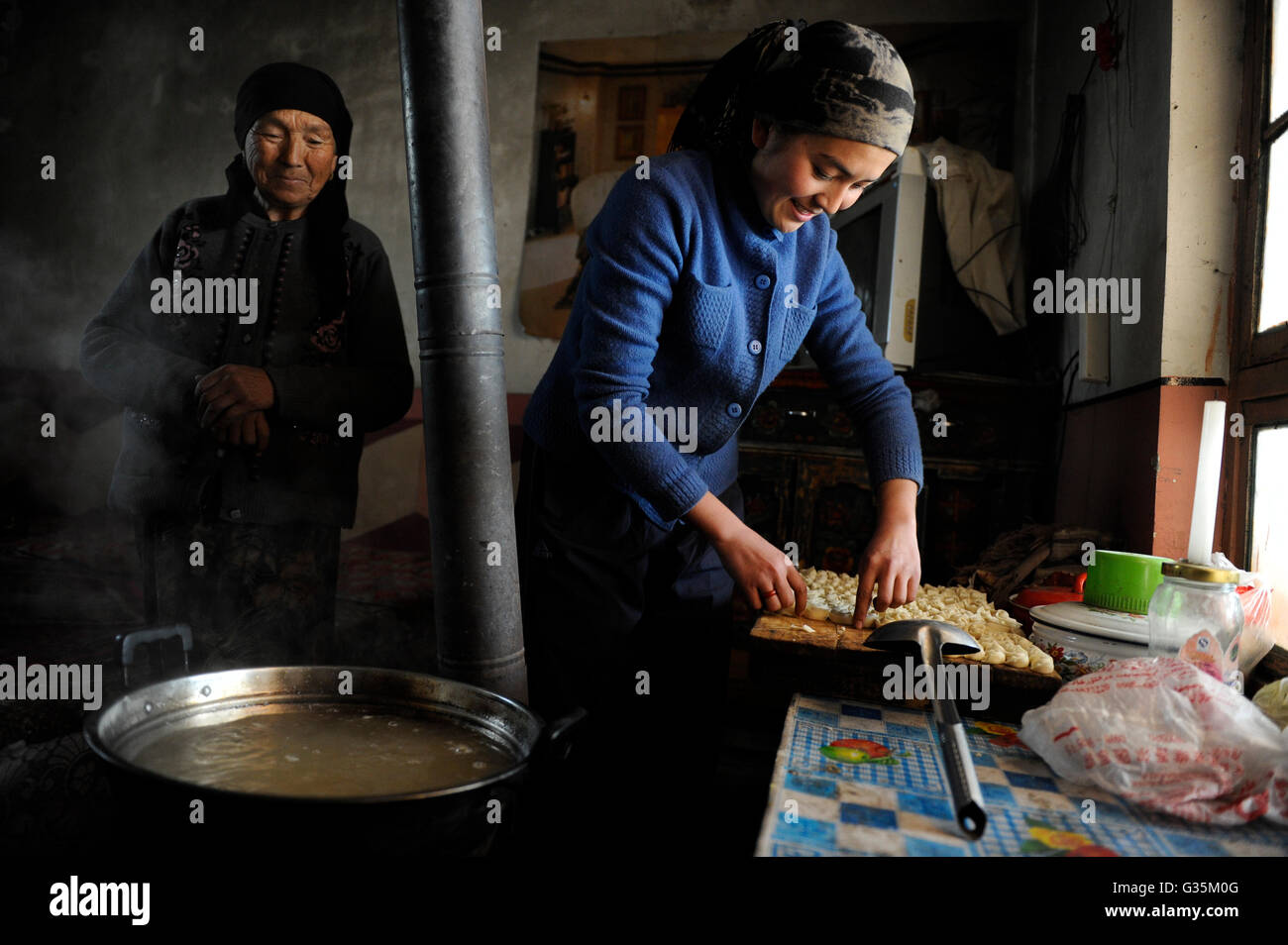 CHINA Provinz Xinjiang, uigurische Dörfer rund um die Stadt Kashgar, wo der Uiguren leben Leute, Frauen essen in der Küche, frische Samsa gefülltes Lamm Fleisch Torte Stockfoto
