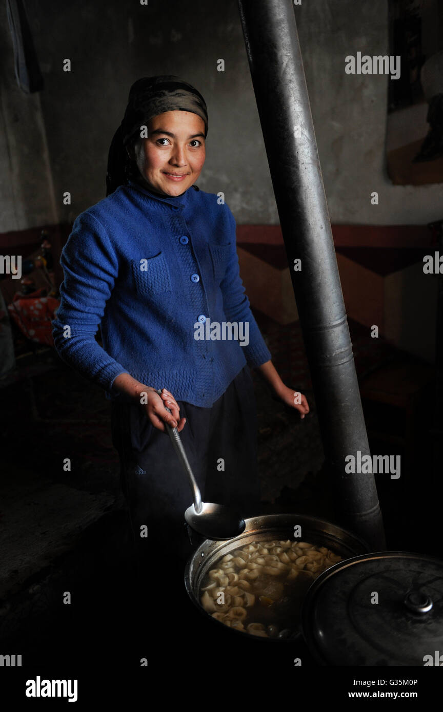 CHINA Provinz Xinjiang, uigurische Dörfer rund um die Stadt Kashgar, wo der Uiguren leben Leute, Frauen essen in der Küche, frische Samsa gefülltes Lamm Fleisch Torte Stockfoto