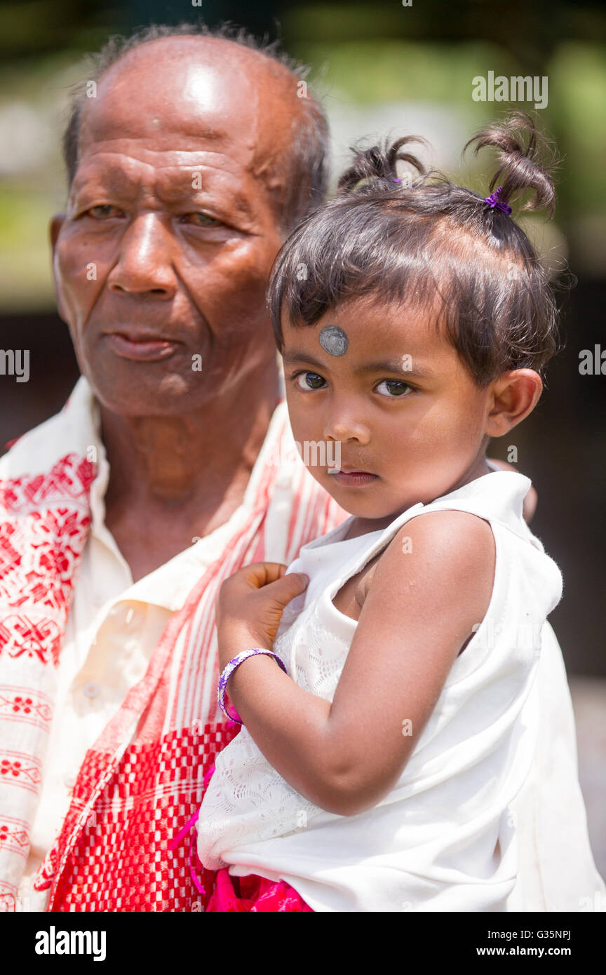 Ein junges Mädchen wird von einem Verwandten in Pan Bari Village im Kaziranga Nationalpark in Indien am 13. April 2016 statt.  Bildnachweis: Stockfoto