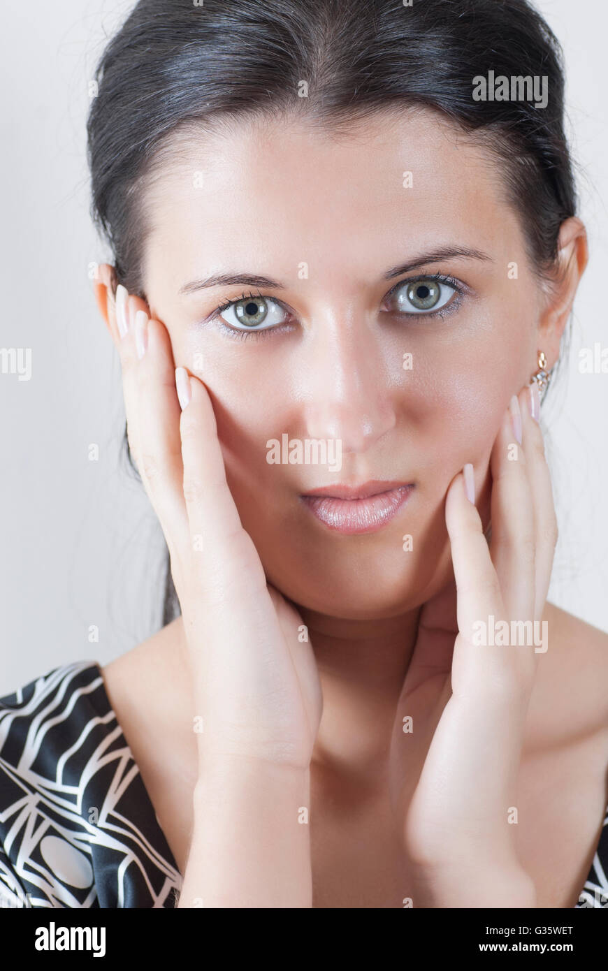 Schöne junge Frau Hände Gesicht berühren Stockfoto