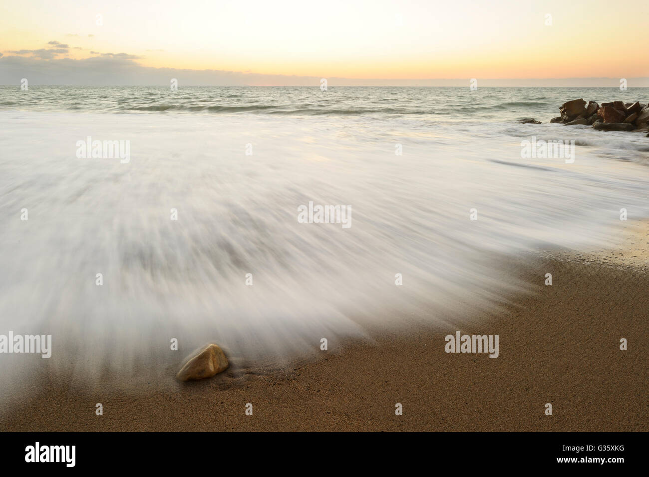 Sunrise Beach ist eine Art abstrakte mit Wellen an das Ufer, eingefroren in der Zeit Stockfoto