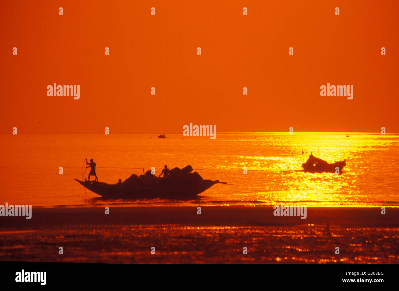 Fischer und ihre Boote bei Sonnenuntergang nach ihrer Tage aus dem Meer, Frasergunj, ländlichen West Bengalen, Indien zu fangen Stockfoto