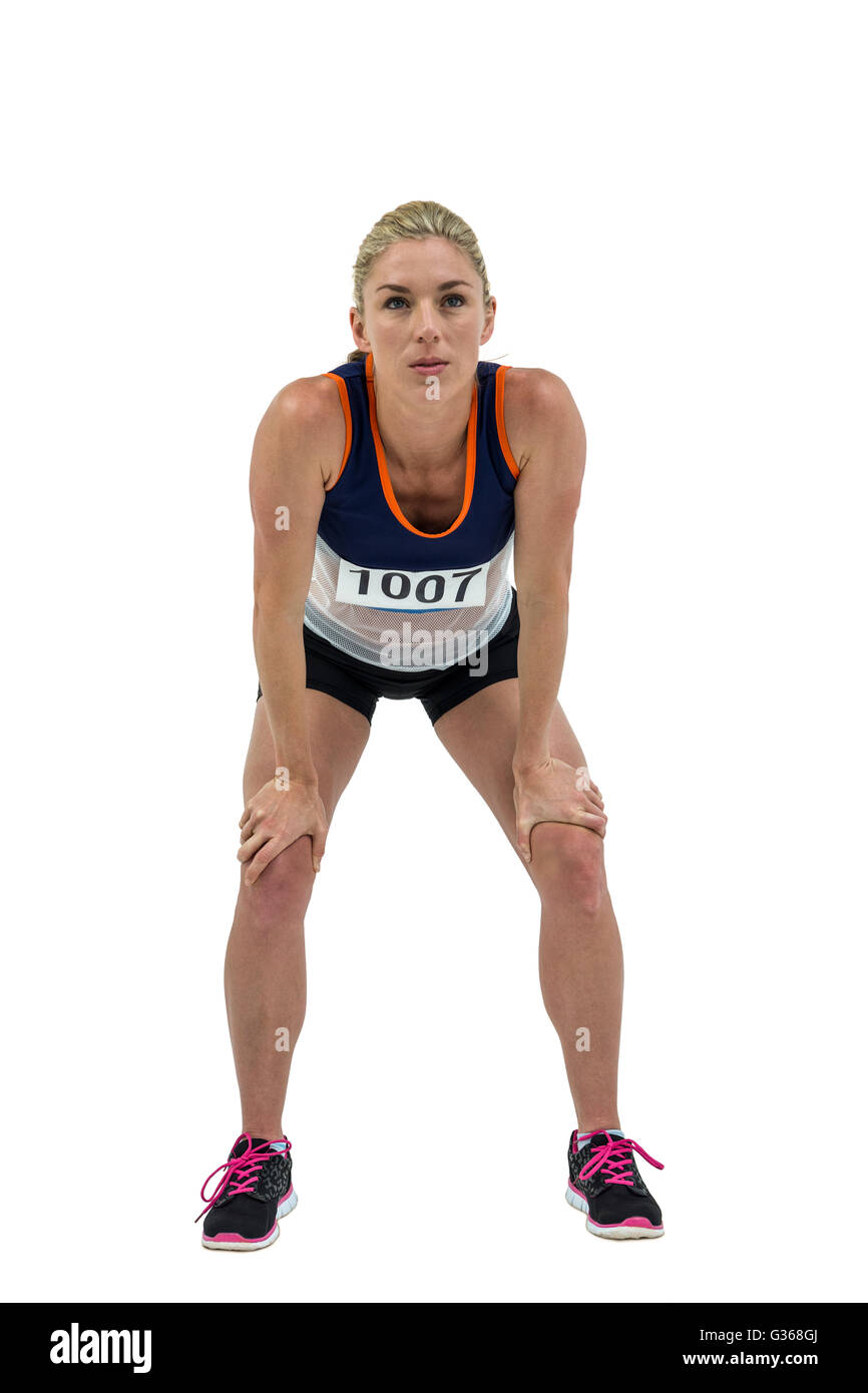 Müde Sportler stehend mit Hand am Knie Stockfoto