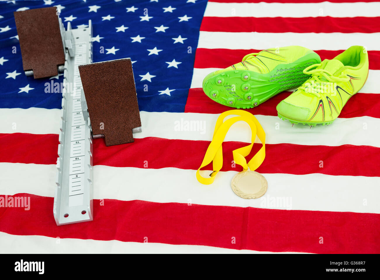 Trainer Schuhe, Startblock und Goldmedaille auf amerikanische Flagge Stockfoto