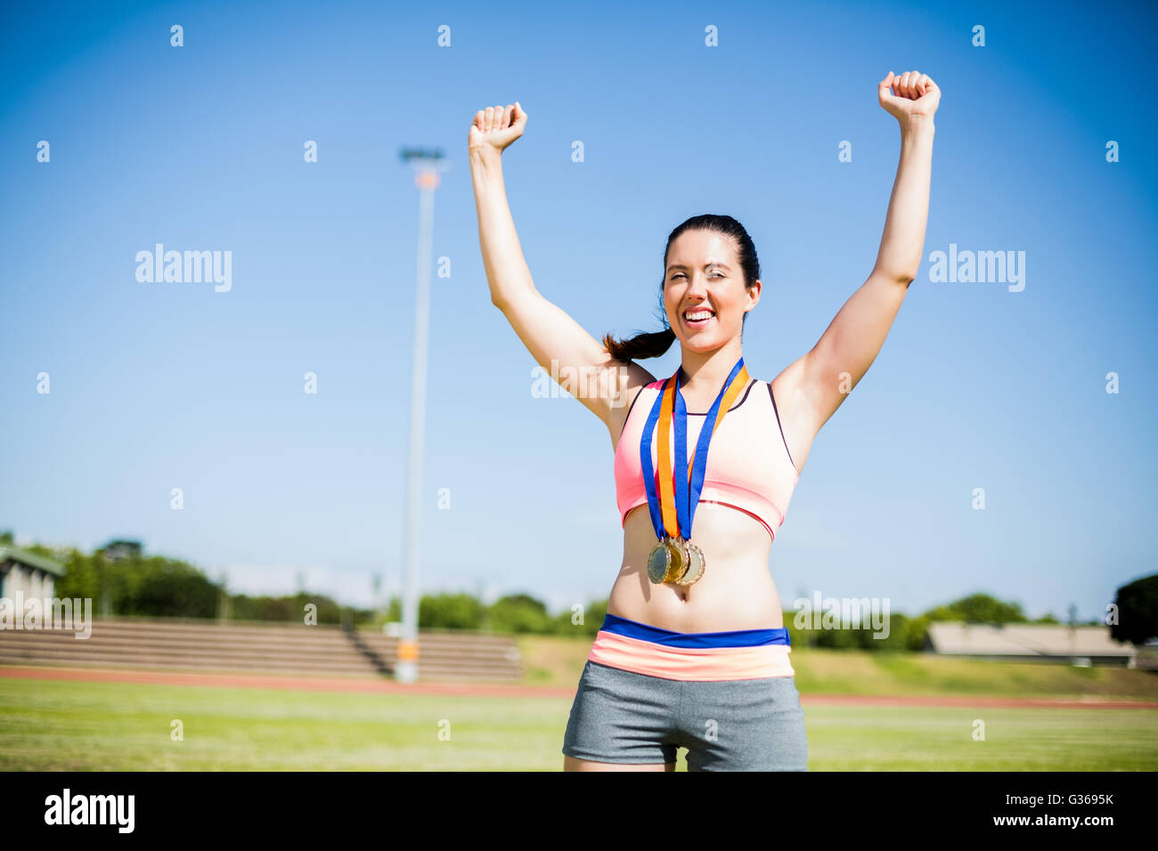 Aufgeregt Sportlerin mit Goldmedaillen um den Hals Stockfoto