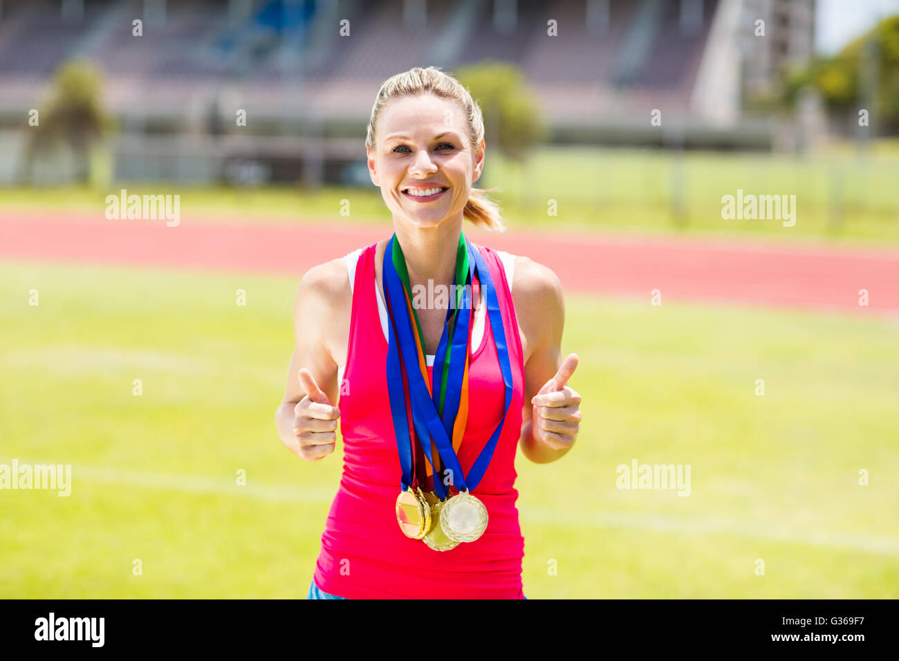 Porträt von glücklich Sportlerin mit Goldmedaillen Stockfoto
