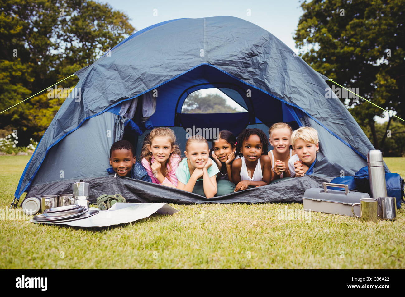 Lächelnde Kinder zusammen im Zelt liegend Stockfoto