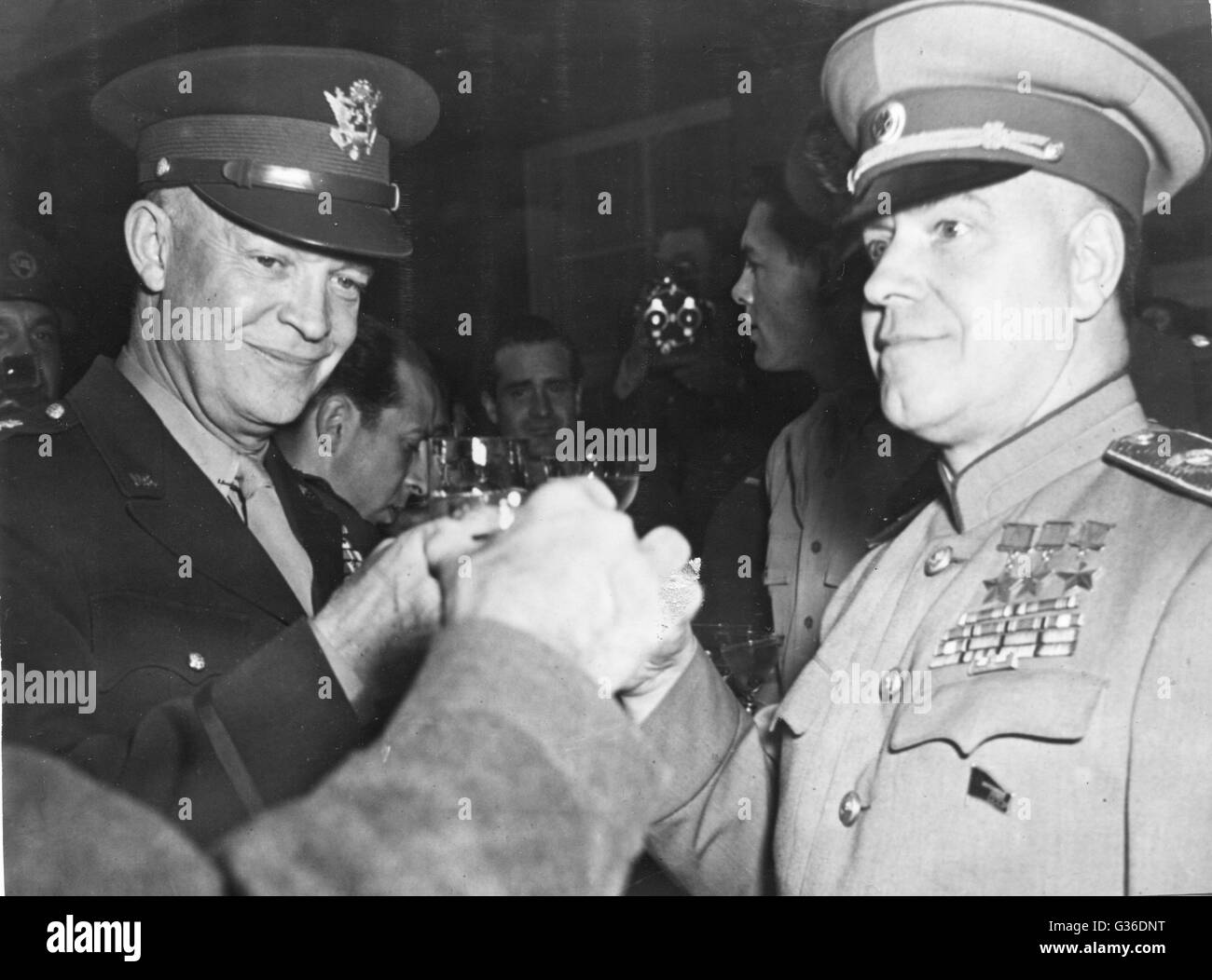 Staats-und Regierungschefs, Supreme Commander General Dwight Eisenhower (links), sowjetischer Marschall Zhukov (rechts) und British General Montgomery (unsichtbare links), stoßen Sie an den Sieg der Alliierten. Stockfoto