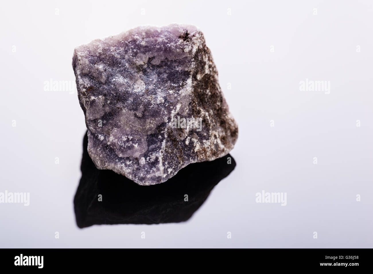 Aufnahme eines Fragments des Minerals Lepidolith auf einem dunklen Untergrund hautnah Stockfoto