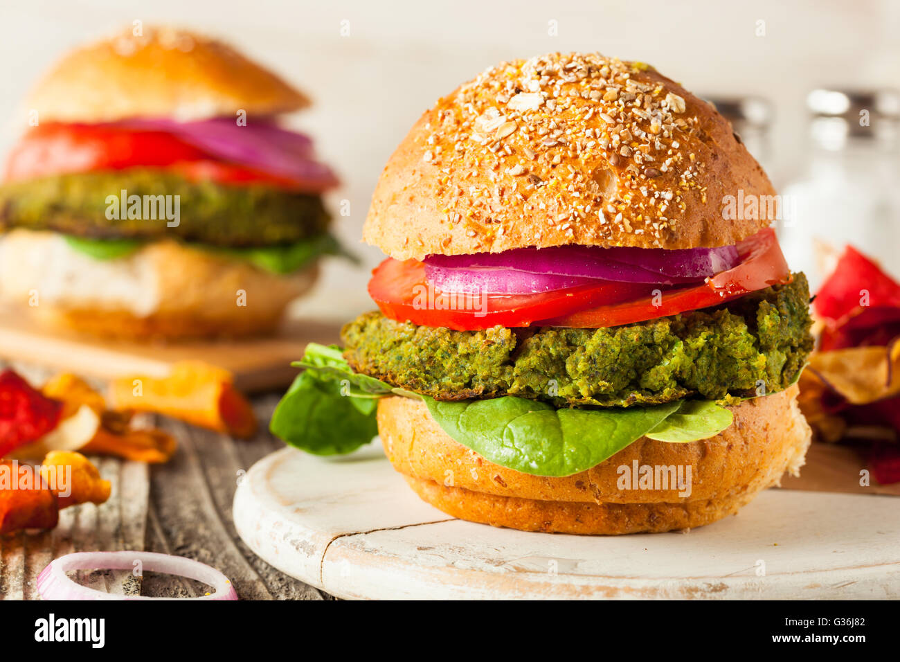 Hausgemachte grüne vegane Burger mit Salat und Tomate Stockfoto