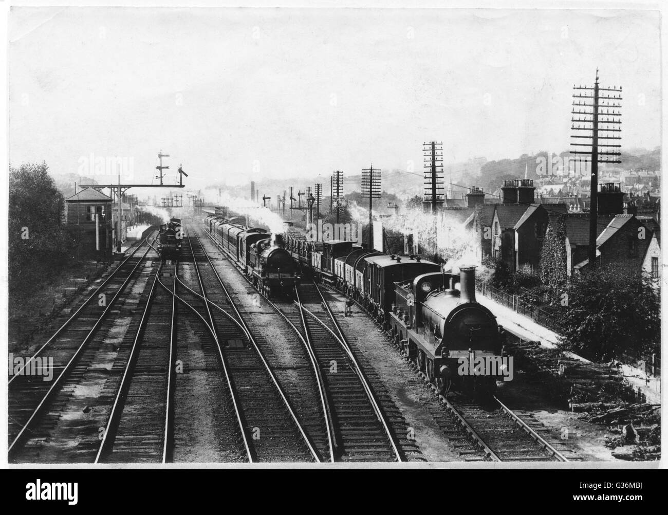 Ein Güterzug wartet auf einer Spur lassen den Personenzug durchlaufen, während ein Dritter Zug Ansätze durch den Bahnhof in Redhill, Surrey.     Datum: 1909 Stockfoto