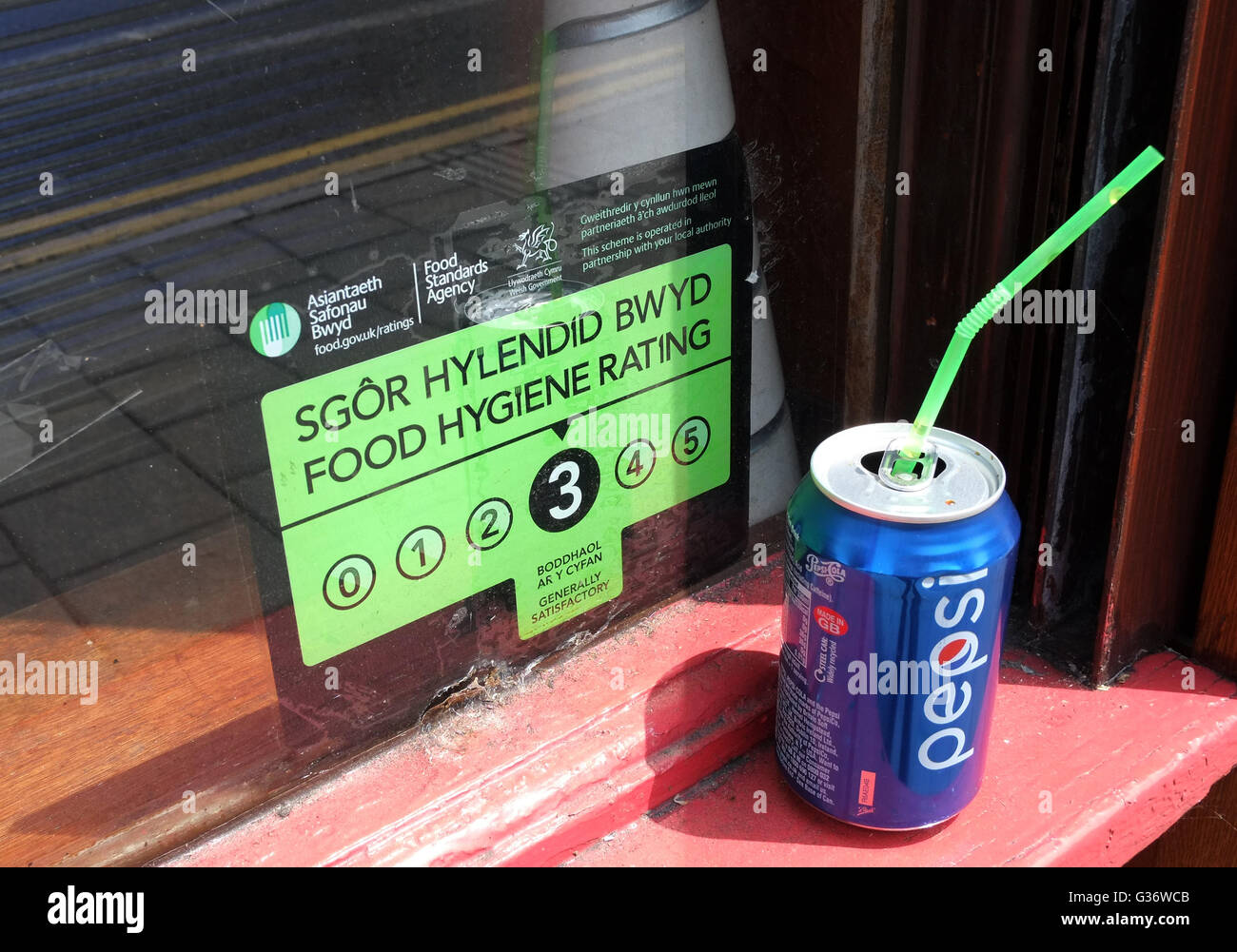 Bi lingual Lebensmittel Hygiene Rating Zeichen 3 in einem Schaufenster Cardiff mit einer Dose Pepsi hinterlassen auf dem Fenster Cill. Juni 2016 Stockfoto