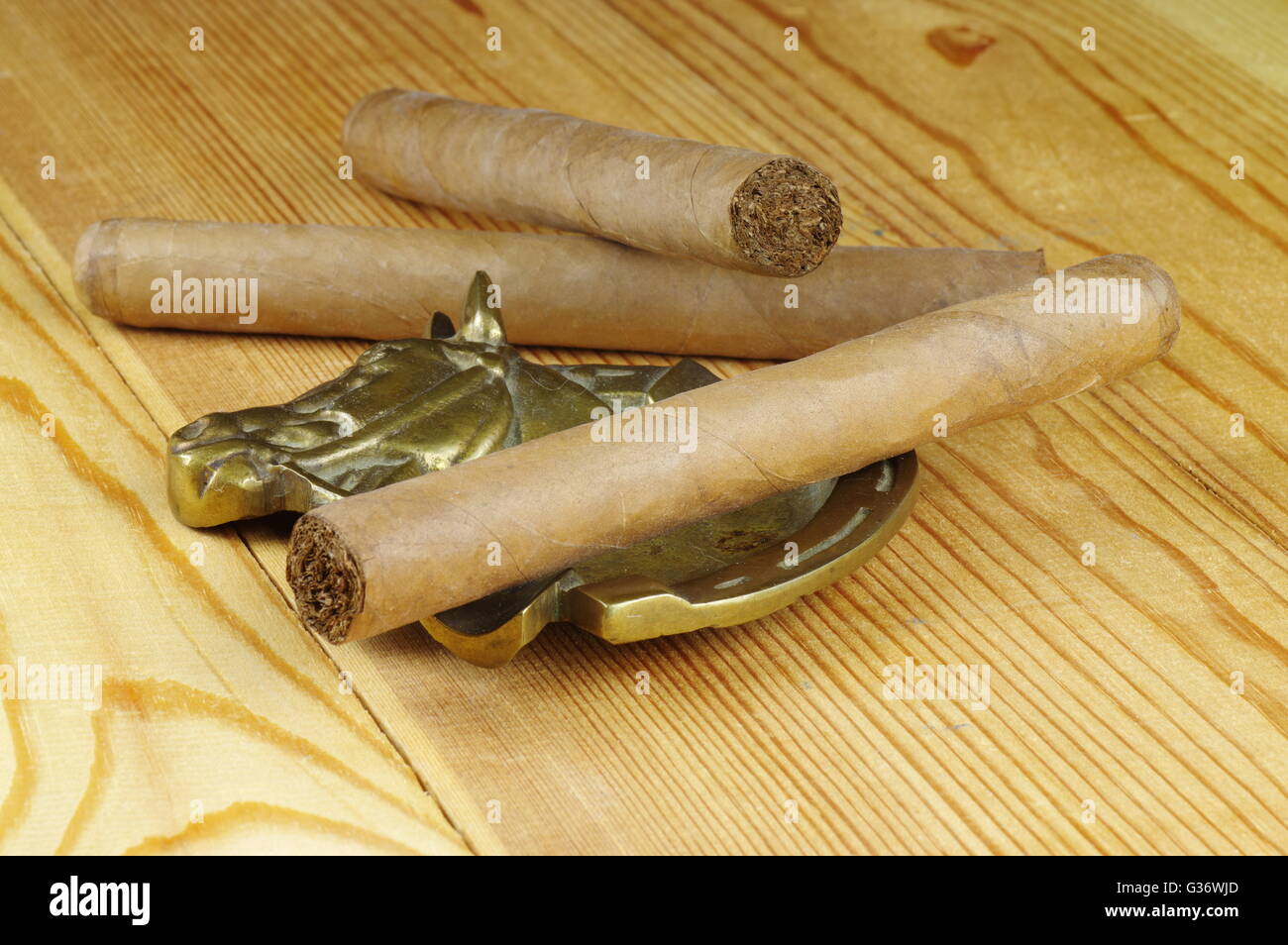 Handgemachte Zigarren und Alt Messing Aschenbecher auf einem Holztisch. Stockfoto