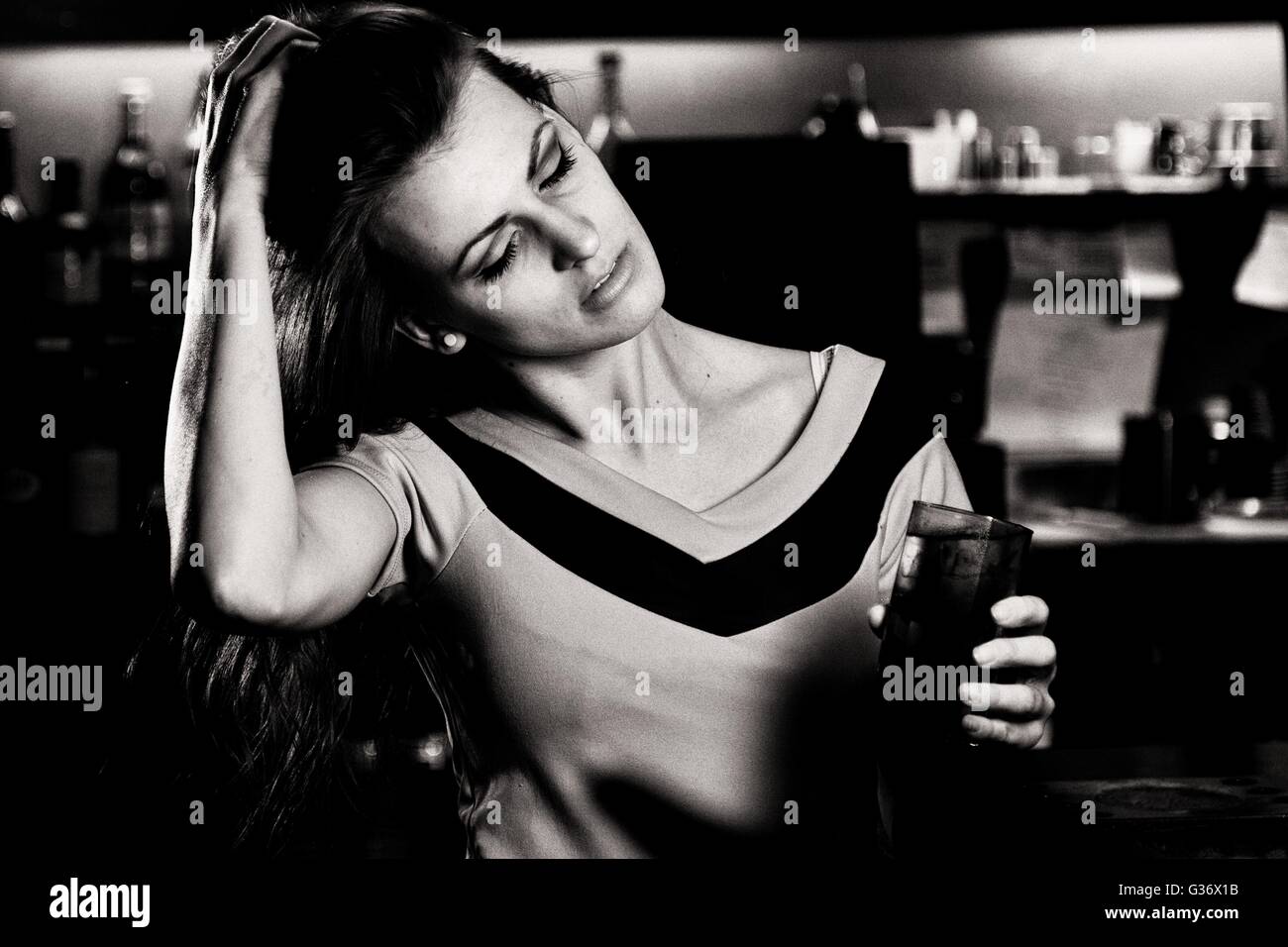 Eine junge Dame trinkt auf ihrer Party und posiert für ein Foto in einer Bar irgendwo in England Großbritannien Stockfoto