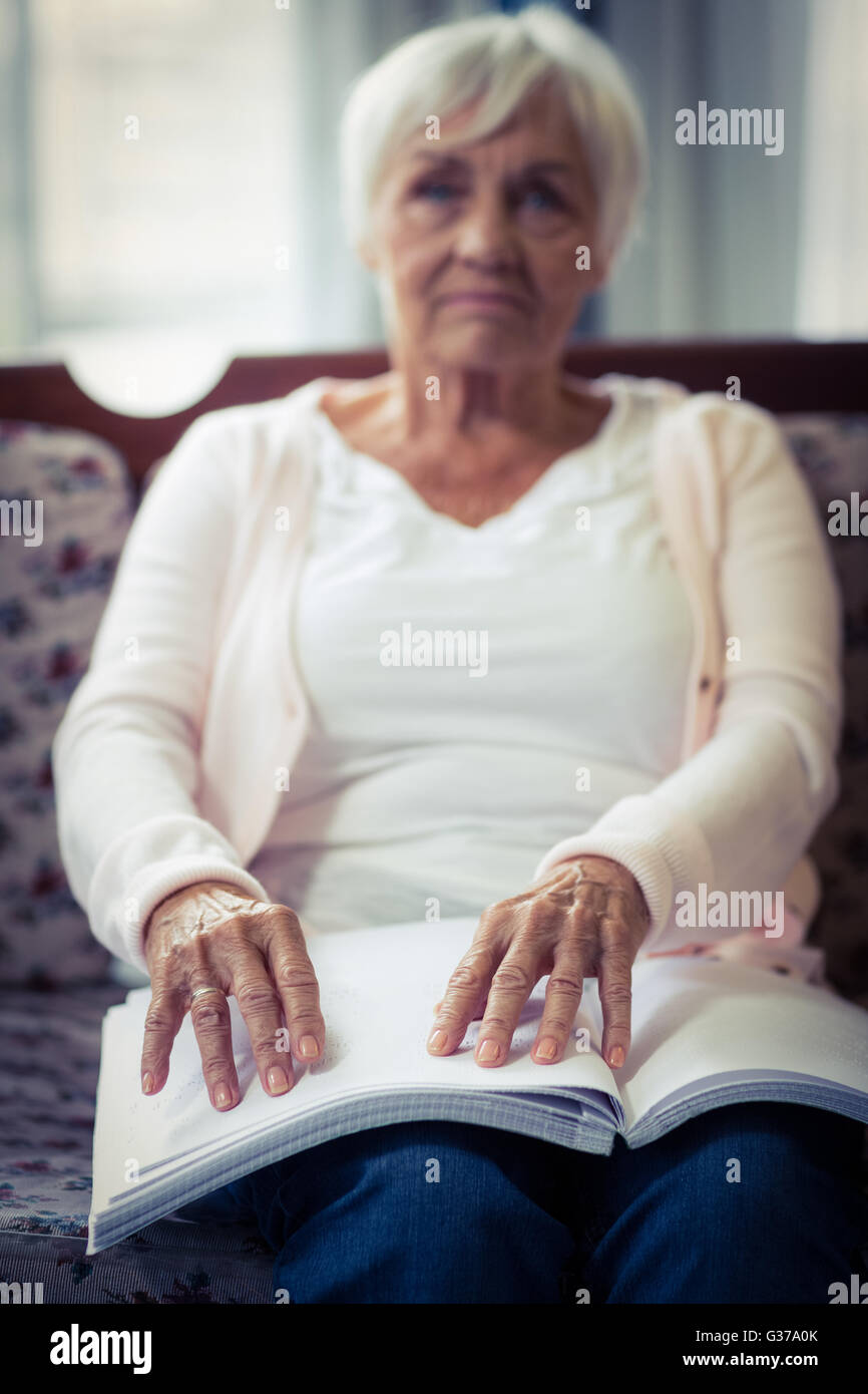 Blinde Frau, die ein Braille-Buch lesen Stockfoto