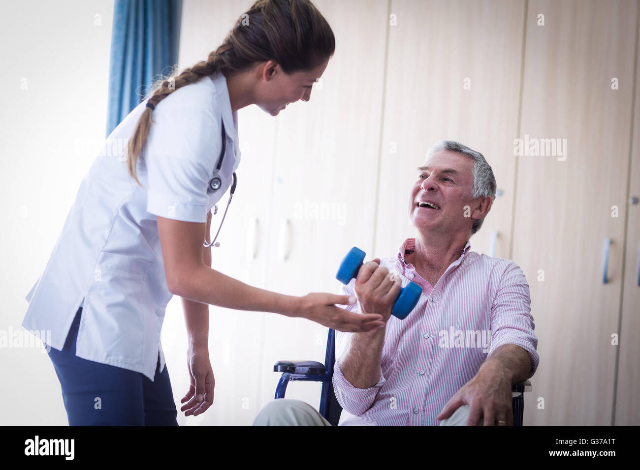 Ärztin, die Unterstützung von senior woman Hantel heben Stockfoto