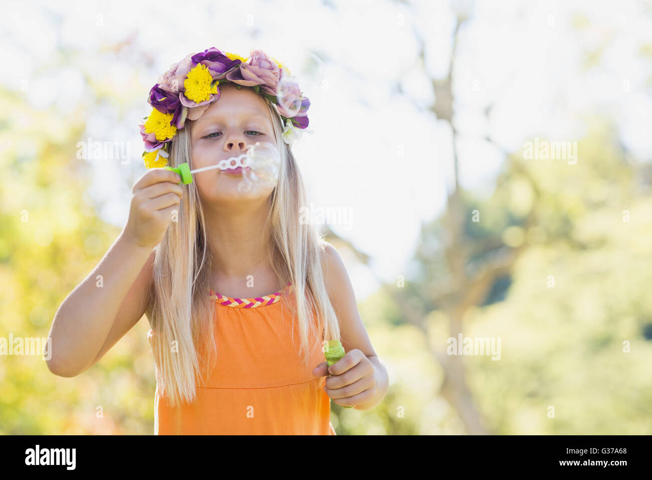 Junges Mädchen bläst Seifenblasen durch Blase Zauberstab Stockfoto