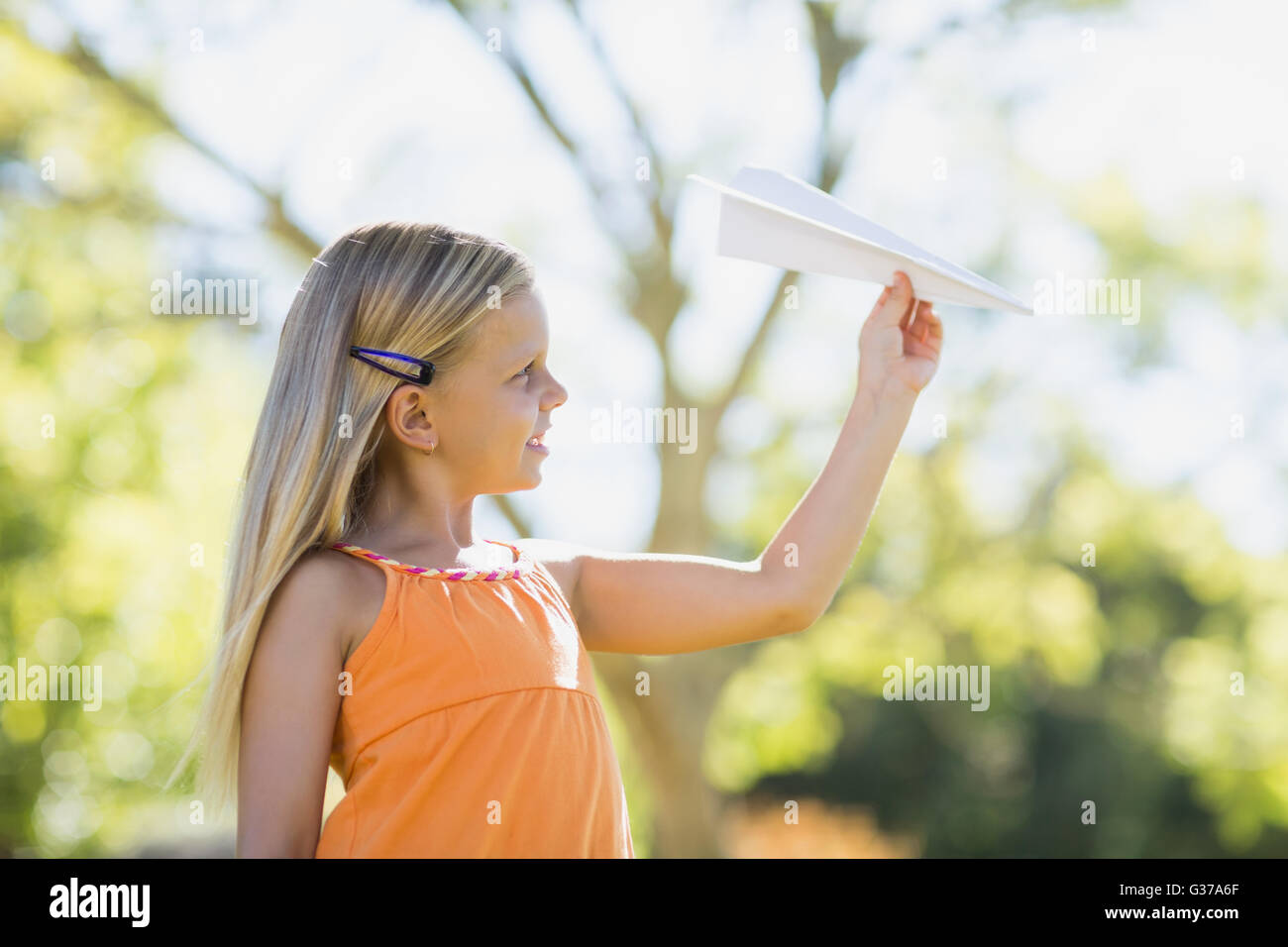 Junge Mädchen spielen mit einem Papierflieger Stockfoto