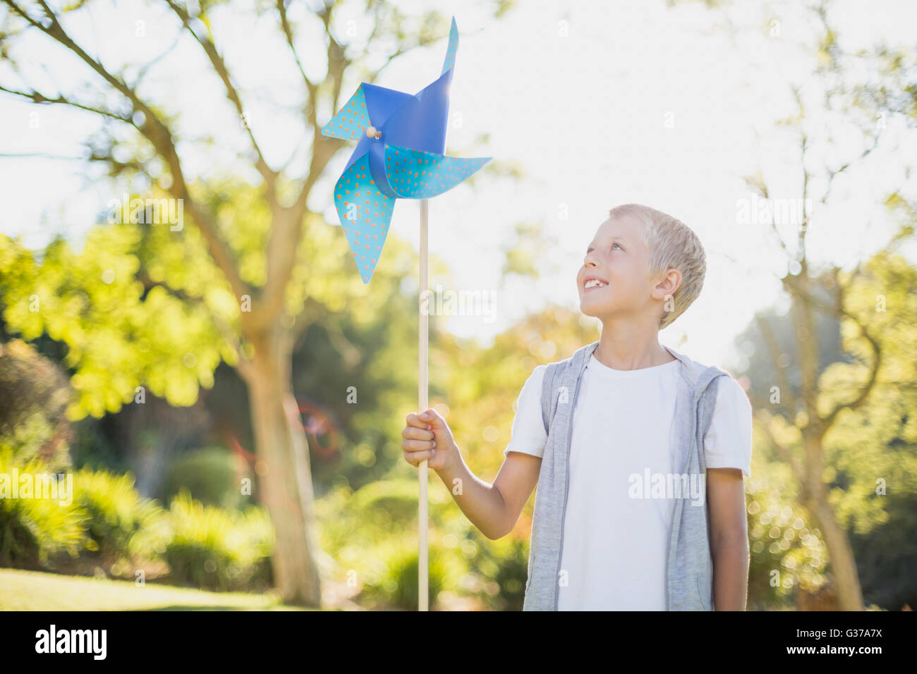 Junge hält ein Windrad im park Stockfoto
