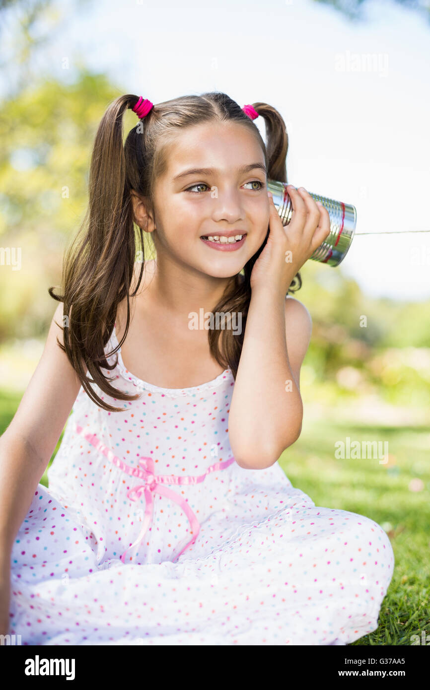 Junges Mädchen hören über Telefon Blechdose Stockfoto