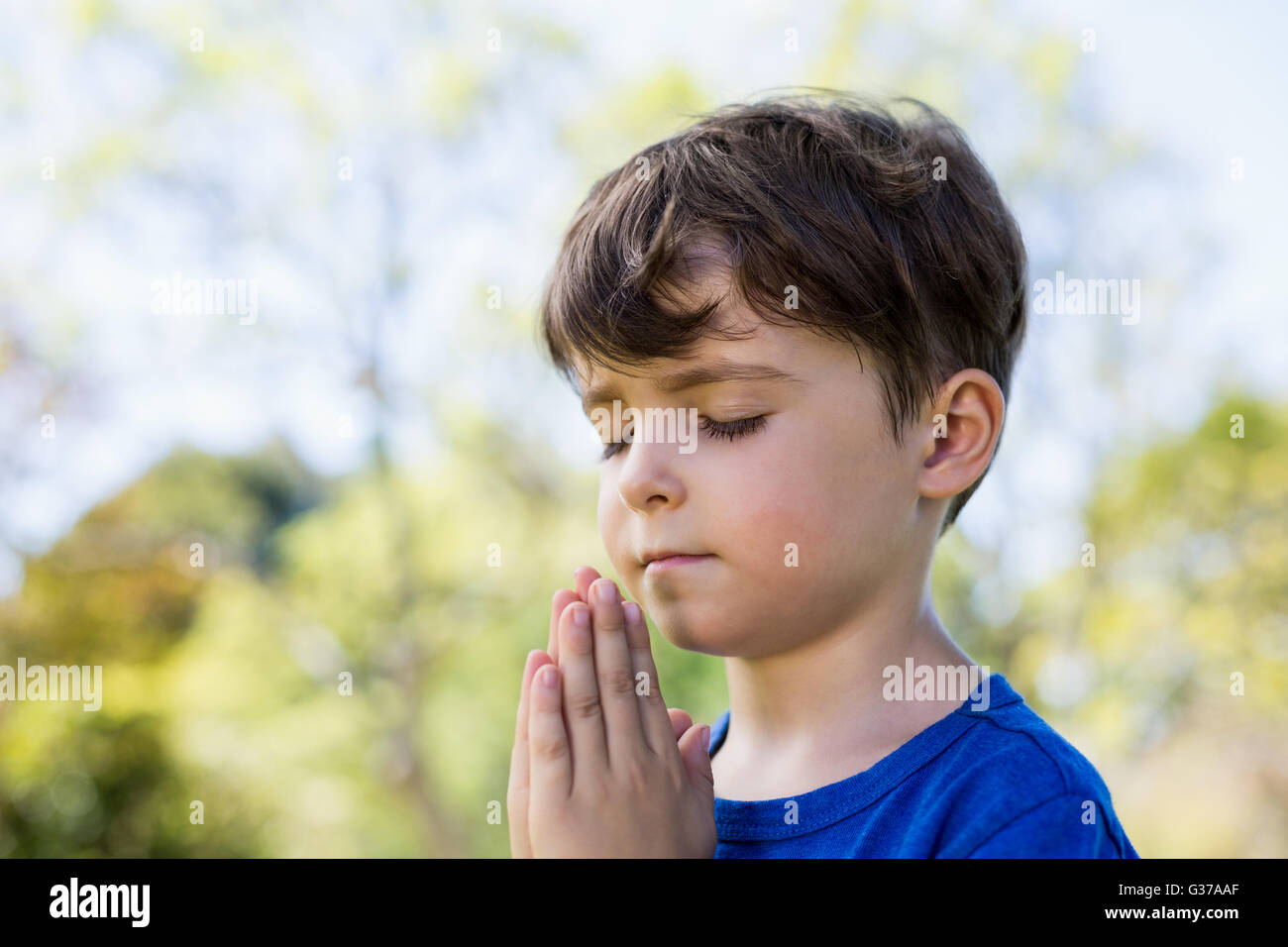 Junge mit geschlossenen Augen zu beten Stockfoto