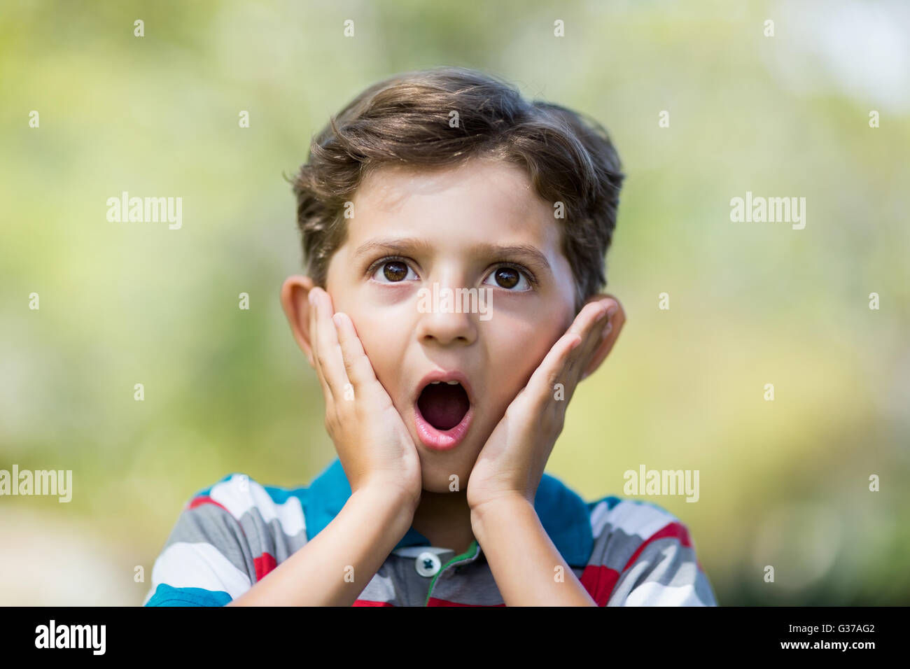 Junge machen Überraschung Ausdruck beim Herausziehen lustige Gesichter Stockfoto
