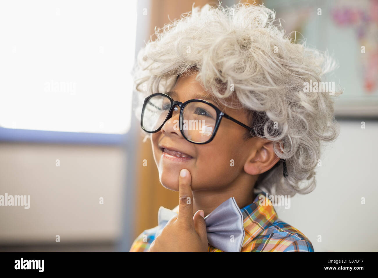 Nachdenkliche Schüler tragen der Perücke im Klassenzimmer Stockfoto
