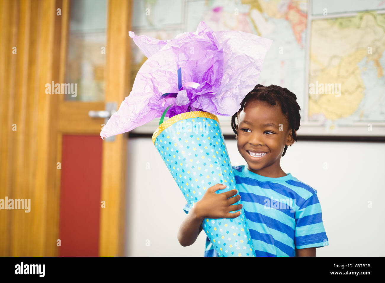 Lächelnd Schüler halten Geschenk im Klassenzimmer Stockfoto