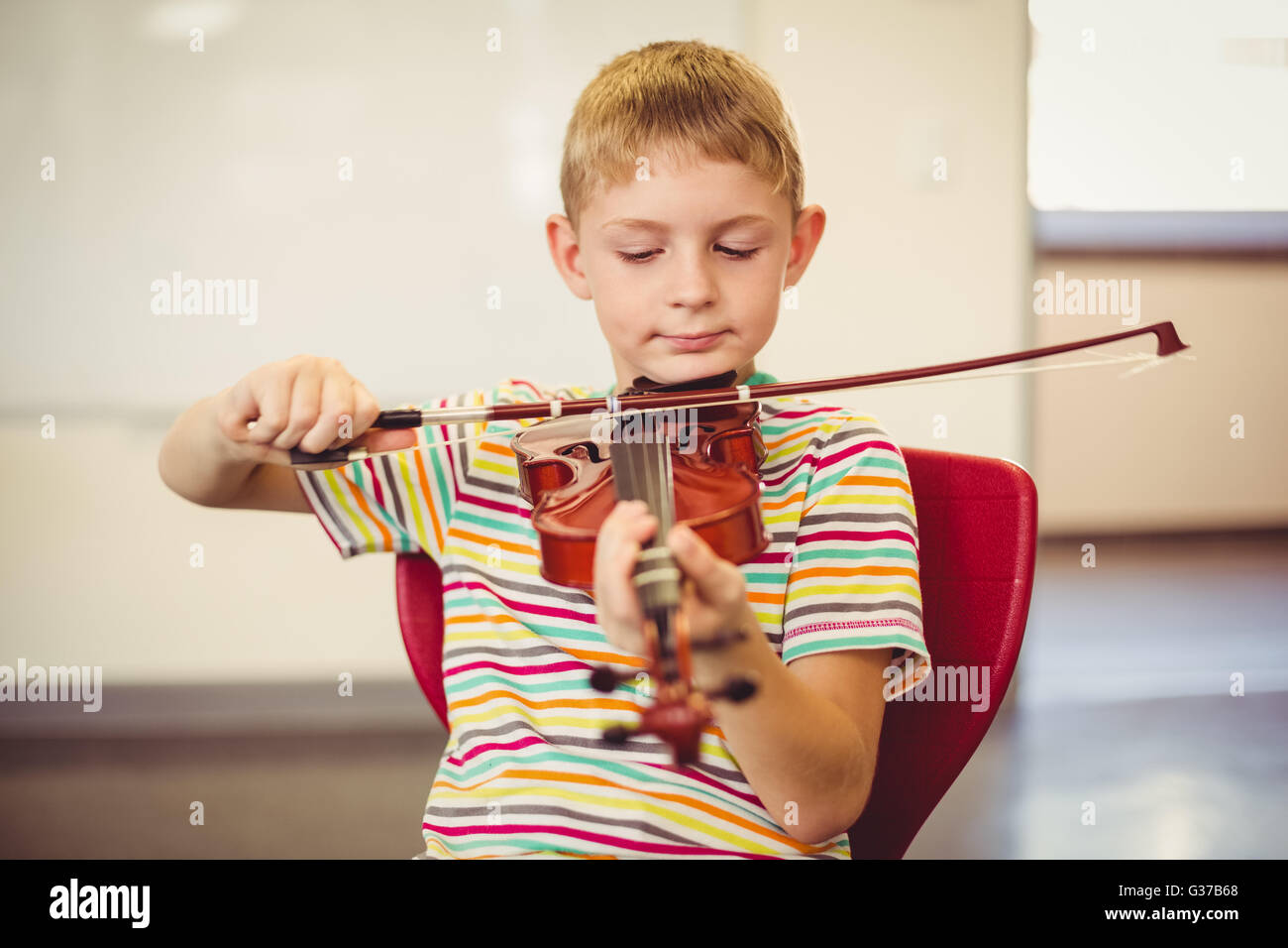 Schüler spielen Violine im Klassenzimmer Stockfoto