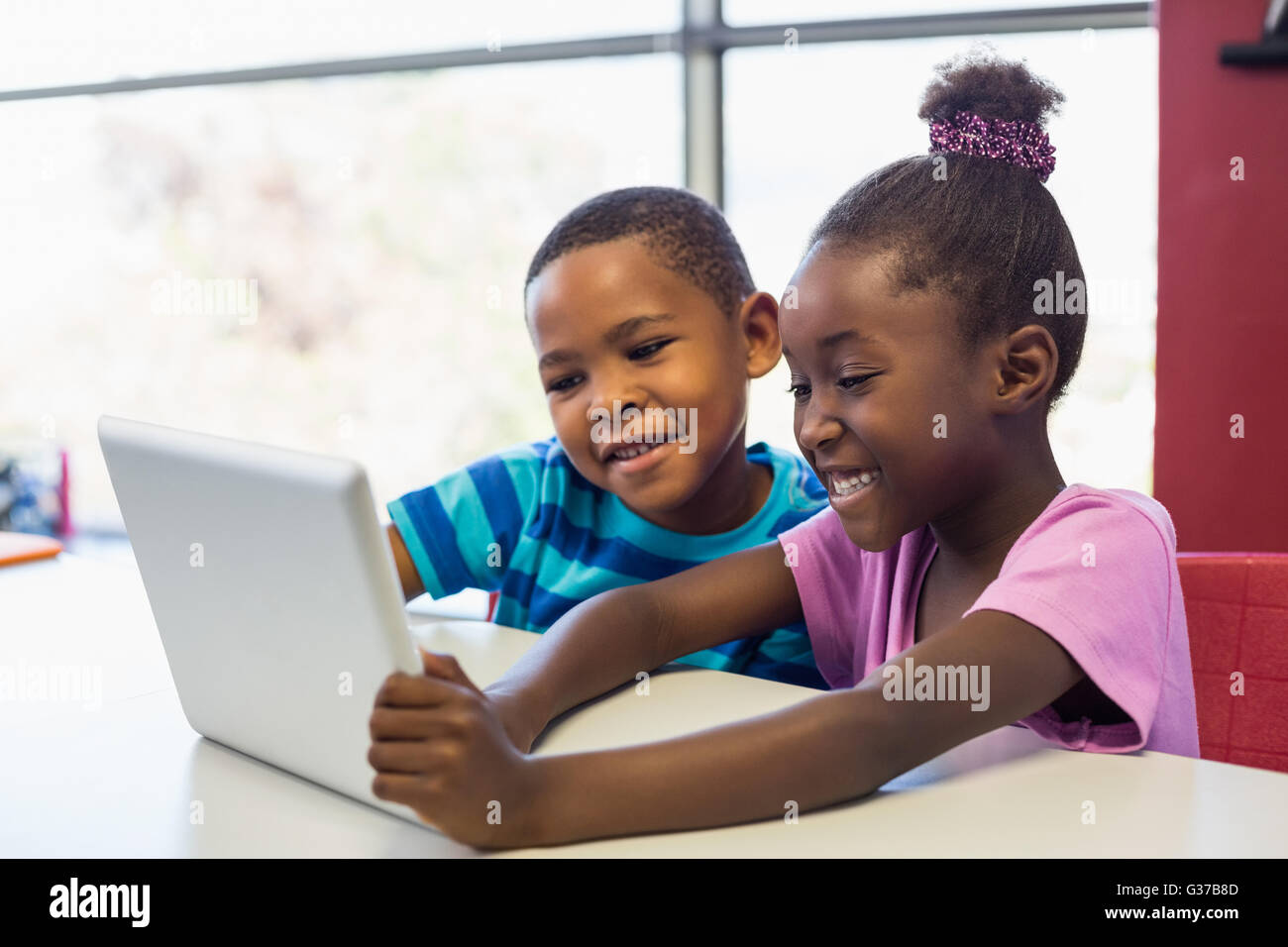 Schülerinnen und Schüler mit einem digitalen Tablet im Klassenzimmer Stockfoto