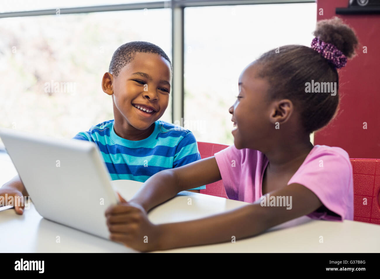 Schülerinnen und Schüler mit einem digitalen Tablet im Klassenzimmer Stockfoto