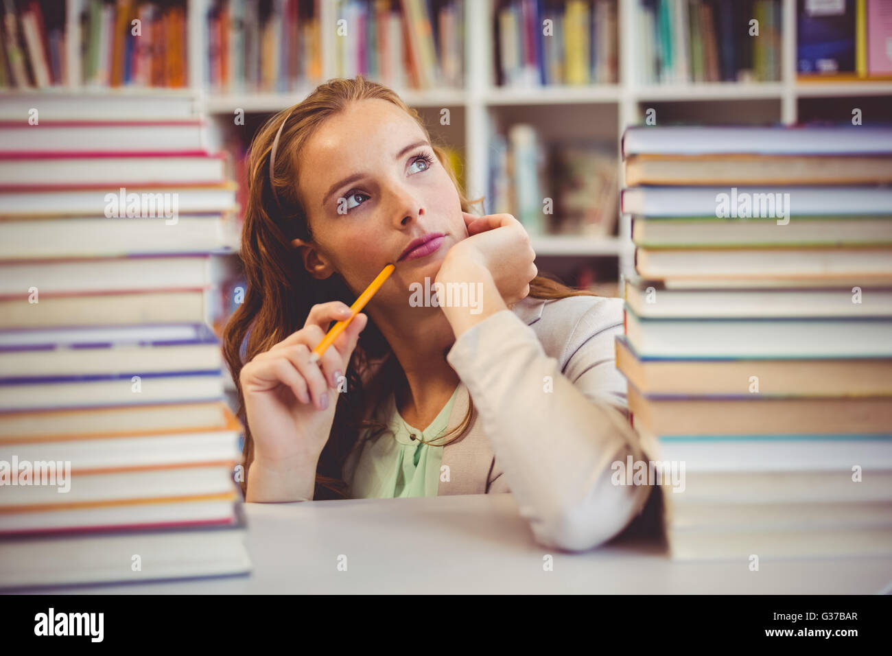 Nachdenklichen Lehrer mit Büchern in der Bibliothek Stockfoto