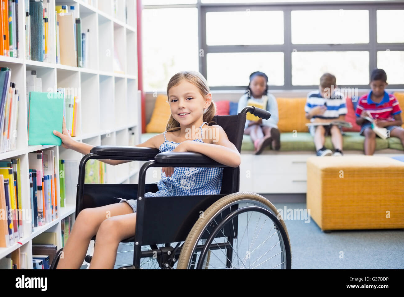Behinderten Schulmädchen Bücherregal in der Bibliothek ein Buch auswählen Stockfoto