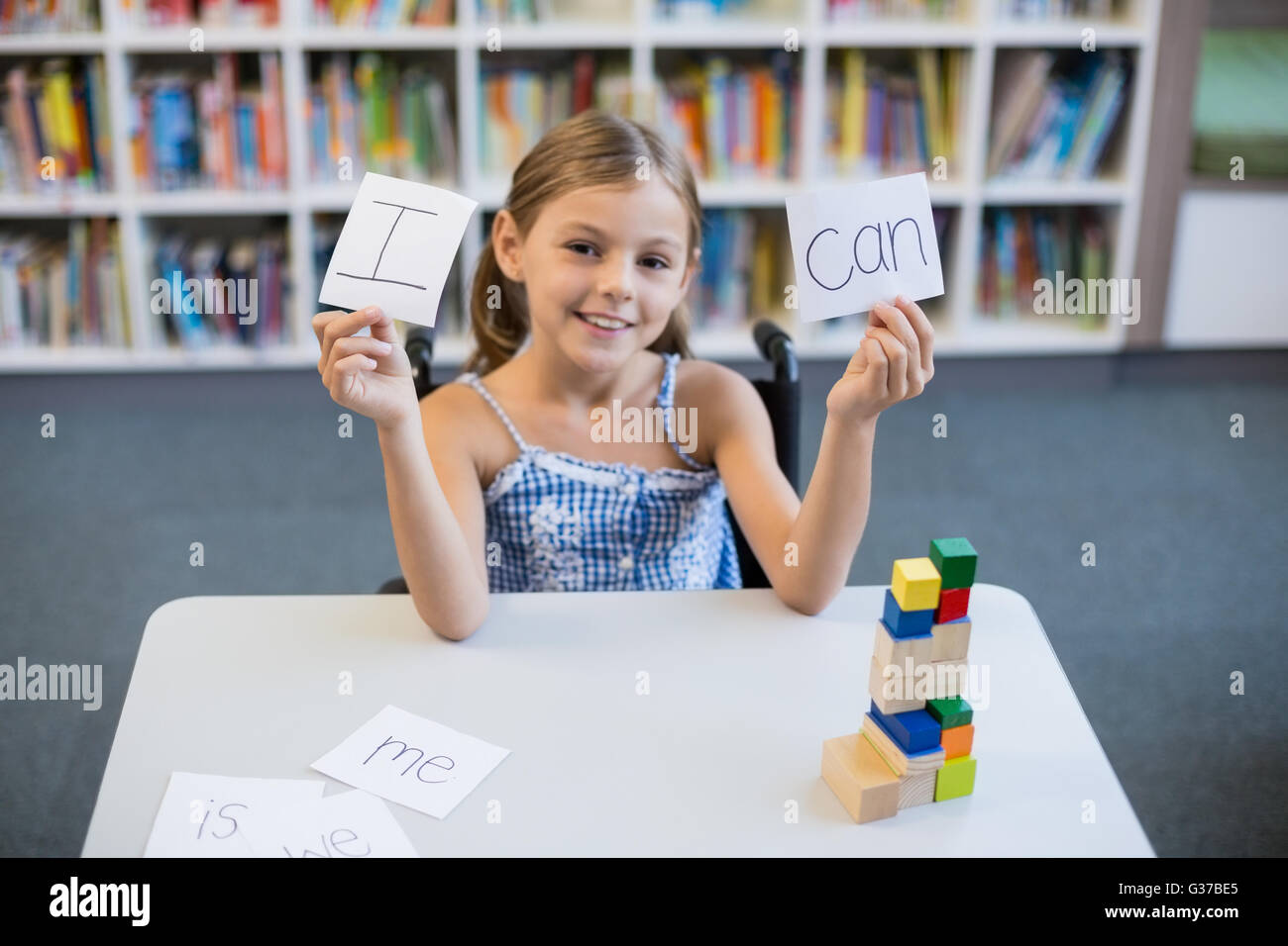 Behindertes Mädchen halten Plakat, das ich kann in der Bibliothek liest Stockfoto