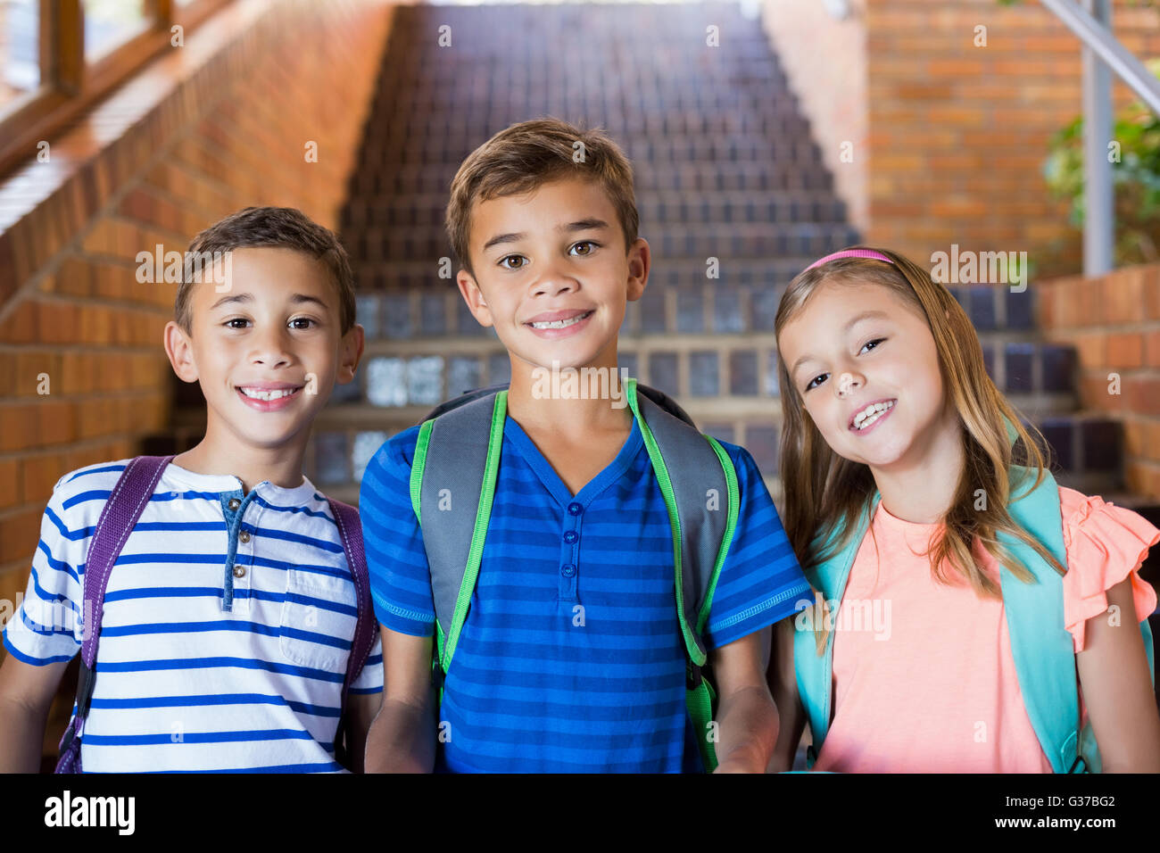 Porträt des Lächelns Schulkinder zusammenstehen auf Treppe Stockfoto