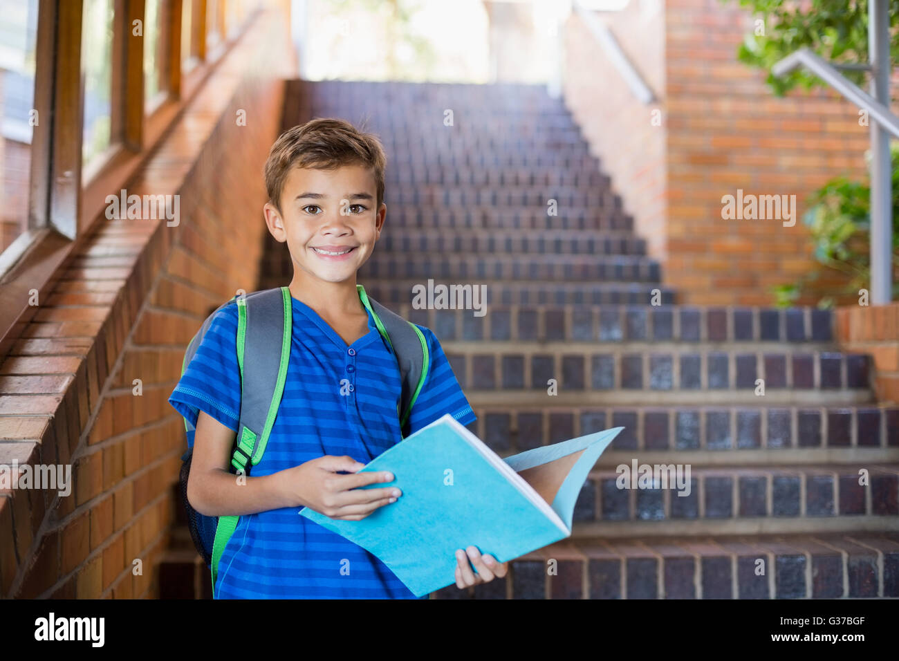 Schüler halten ein Buch über Treppe Stockfoto