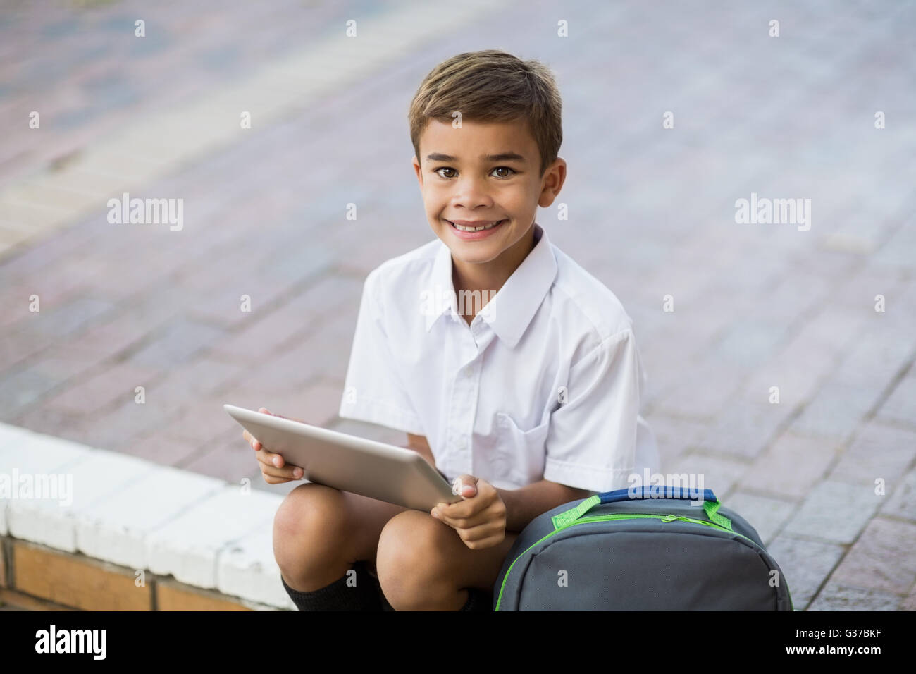 Glückliche Schüler sitzen im Campus und mit digital-Tablette Stockfoto