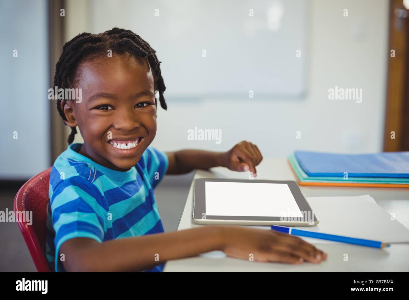 Glückliche Schüler mit digital-Tablette im Klassenzimmer Stockfoto