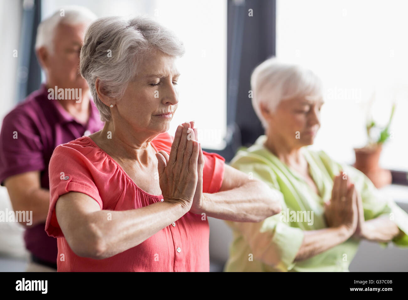 Senioren Yoga mit geschlossenen Augen machen Stockfoto