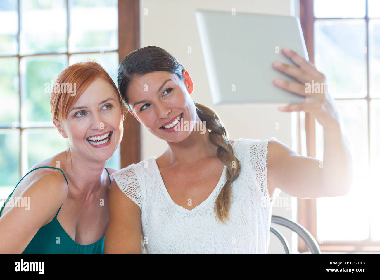 Zwei schöne Frauen, die die Selfie mit digital-Tablette Stockfoto