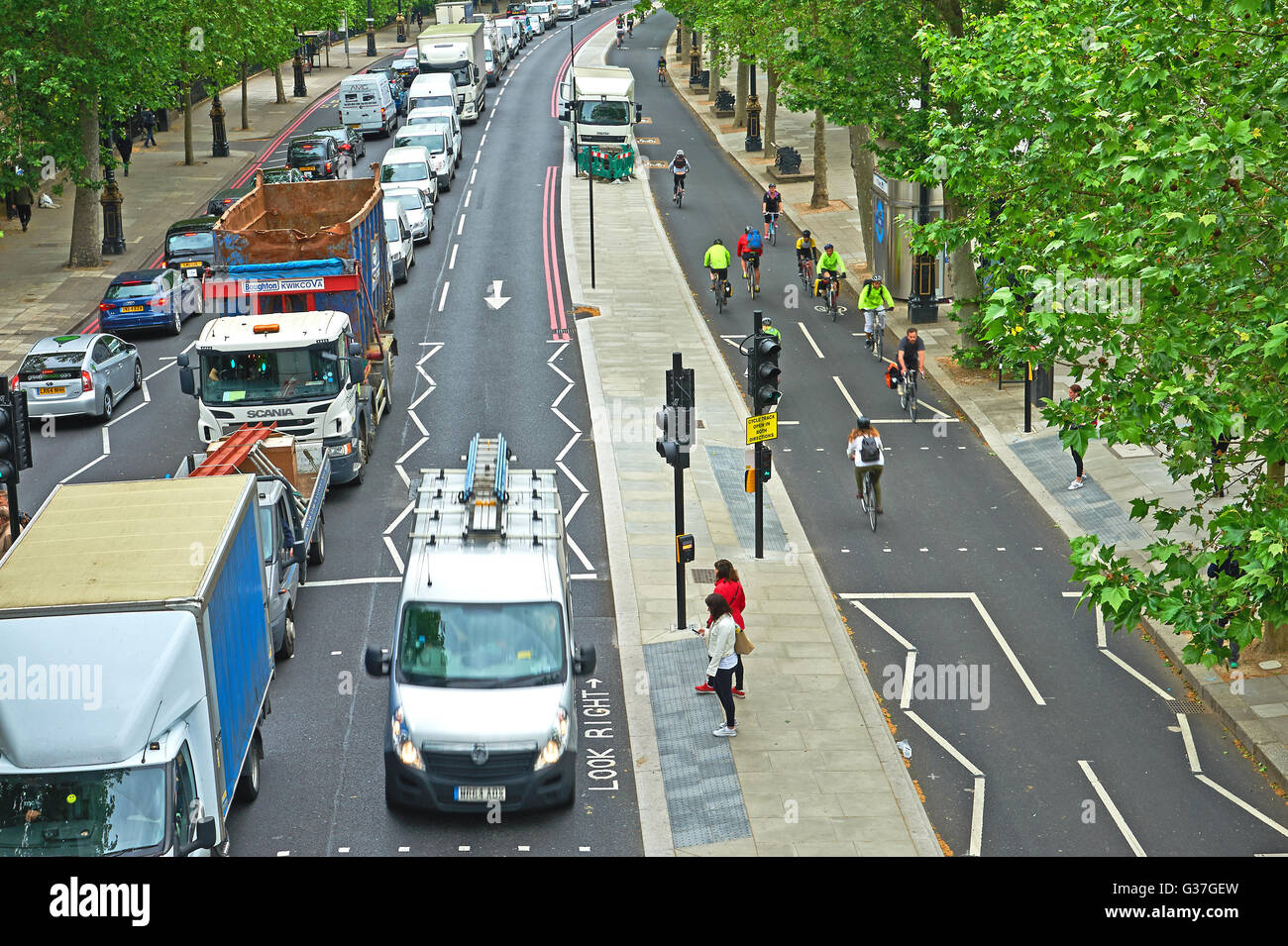 Verkehr, die Schlange am Victoria Embankment im Zentrum von London, während Pendler vorbei auf dem neuen zwei-Wege-Radweg radeln Stockfoto